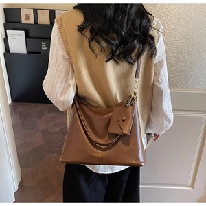 Dettaglio di una borsa tote grande in pelle marrone vintage con pochette rimovibile