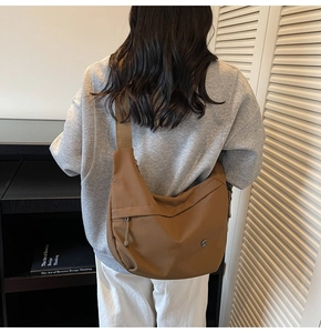 Détails de l'arrière d'un grand sac bandoulière marron en nylon de style décontracté