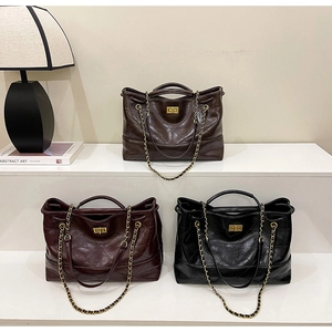 Detailed view of quilted oil wax leather tote bags with gold chains in multiple colors
