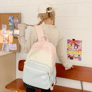 Detail of macaron-colored backpack with multiple pockets and pastel color blocking design