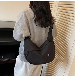 Détail du sac croissant en nylon noir avec bandoulière large et logo F en métal