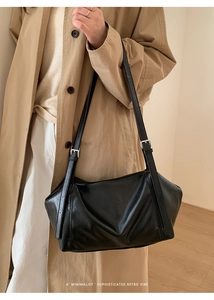 Détail du sac cabas noir montrant la texture du cuir et la boucle métallique argentée