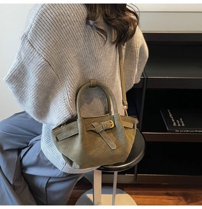 Sac seau vert olive avec surpiqûres en losanges porté par un mannequin
