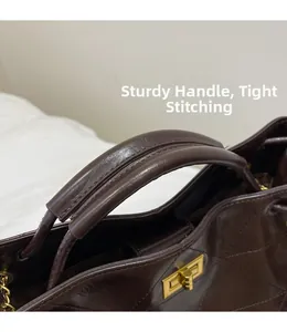 Detail of sturdy handle and tight stitching on dark brown quilted leather tote bag