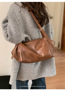 Détail de la boucle en argent réglable sur un grand sac à bandoulière en cuir marron