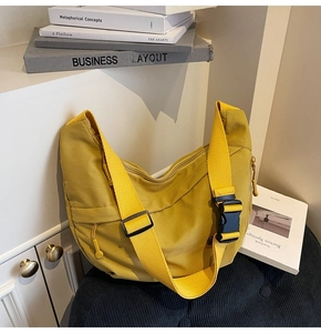 Détail du sac hobo en nylon jaune avec large bandoulière et grande boucle noire