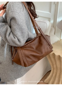 Détail du sac rétro marron foncé avec texture lisse et garnitures métalliques argentées