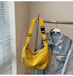 Détail du sac croissant en nylon jaune avec boucle industrielle et sangle réglable
