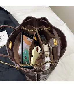 Detail view of large dark brown tote bag with multi-compartment interior for iPad and items