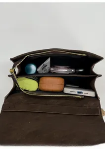 Vista interior del bolso bandolera de cuero marrón con amplios compartimentos internos