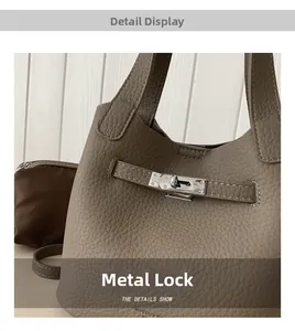 Detail of silver twist lock and pebbled leather texture on grey bucket handbag
