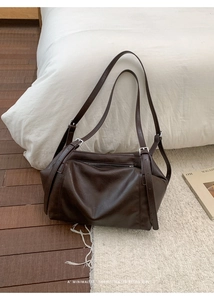 Detail view of a minimalist deep brown retro shoulder bag with matte leather texture