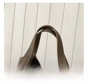 Detail of brown litchi pattern leather bucket bag with silver metal twist lock and stitching
