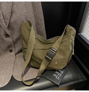 Détail du sac demi-lune en nylon vert militaire avec boucle noire et logo en métal