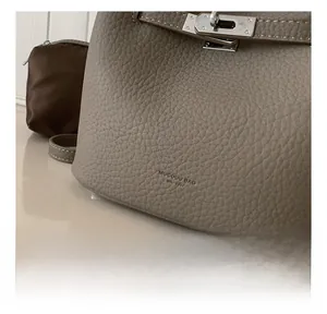Close-up of gray lychee leather texture and silver buckle on a luxury bucket bag