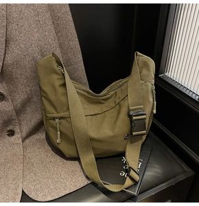 Détail de la sacoche en nylon vert armée avec boucle tactique et poches fonctionnelles