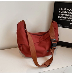 Détail du sac bandoulière en nylon terre cuite avec large sangle et boucle de réglage
