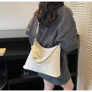 Dettaglio della grande borsa tote bianca con piccola tasca appesa e metallo dorato