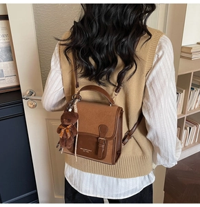 Detail of vintage patchwork leather mini backpack with plush bear charm and buckle