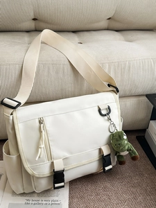 White waterproof nylon messenger bag with large capacity and cute dinosaur plush charm