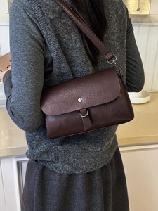 Deep brown crossbody bag in textured faux leather with silver metal buckle detail