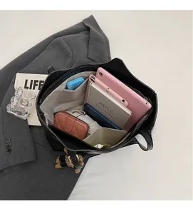 Interior view of the black tote bag showing large capacity and multi-layer compartments