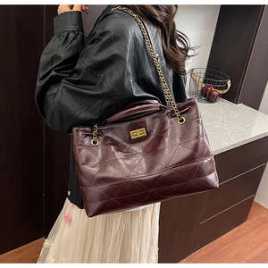 Détail du grand sac cabas matelassé bordeaux avec chaîne dorée et fermoir rotatif