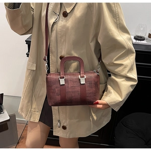 Close-up of deep wine red Boston bag with textured finish and silver metal hardware