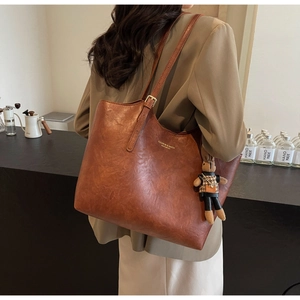 Brown tote bag with pleated texture, adjustable strap and cute bunny doll charm detail