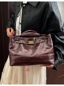 Sac fourre-tout matelassé bordeaux avec chaîne dorée et fermoir tournant sur modèle