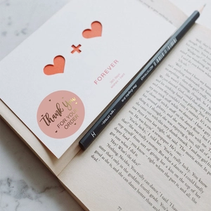 Pink gold foil Thank You stickers with white heart card and pencil on marble