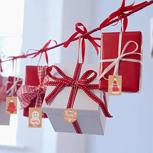 Christmas gift boxes set with kraft paper tags and red ribbons hanging on a rope