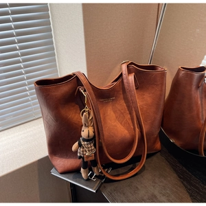 Macro view of brown tote bag with fashion lettering and cute rabbit doll charm