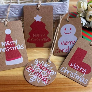 Retro kraft paper Christmas tags with Santa hat and jute twine on rustic wooden surface