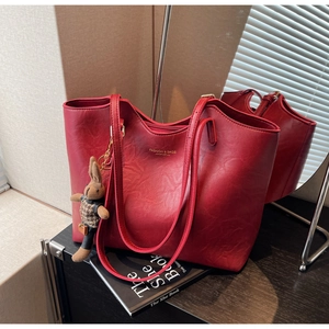 Detail of red vintage tote bag with gold lettering and a cute plaid bunny charm