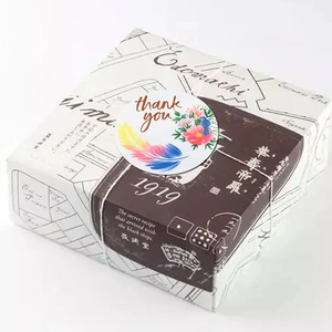 Adhesive thank you stickers with feather and bird designs on a gift box wrap