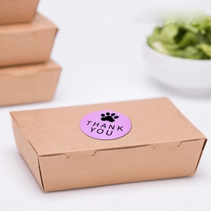 Detail eines Kraftpapier-Essensbehälters mit violettem Katzenpfoten-Dankesaufkleber
