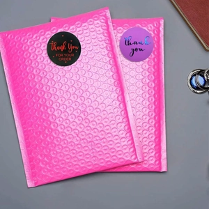 Close-up of pink bubble mailers with decorative Thank You stickers and shockproof texture