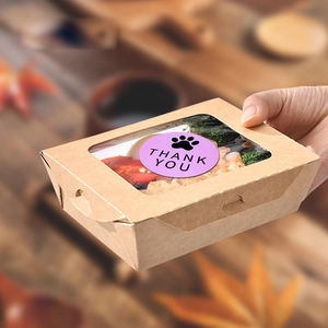 Nahaufnahme einer Kraftpapier-Box mit Sichtfenster und lila Thank You Pfoten-Sticker