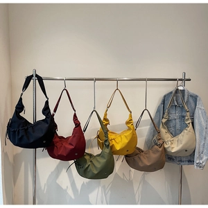 Group display of colorful nylon hobo bags featuring drawstring pleated details