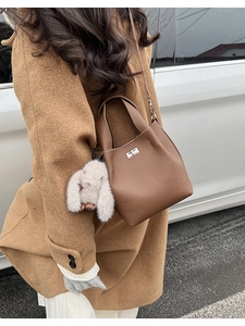 Detail of brown litchi pattern leather bucket bag with silver lock and rabbit charm