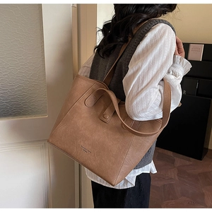 Retro brown faux leather tote bag with fashion trend text shown on a female model
