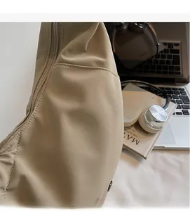 Detail of the soft khaki nylon shoulder bag with premium stitching and zipper closure