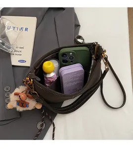 Détail de la grande capacité intérieure du sac à bandoulière marron avec breloque peluche