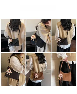 Plusieurs vues d'un sac seau rétro en noir et marron avec un pendentif de lion
