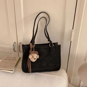 Minimalist matte dark grey tote bag with woven texture and cute bear charm accessory