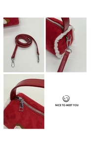 Detail of red plush cylinder bag with faux shearling trim and metal zipper hardware