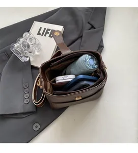Detail of spacious interior with compartments showing a phone and umbrella inside the bag