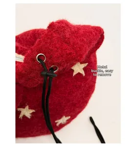 Detail of red plush bag with star pattern featuring hardware buckle and drawstring clasp