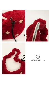 Detail of red plush bag showing the silver metal zipper and soft fleece handle texture